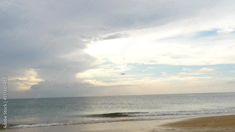 Beautiful panoramic view of an airplane flying over the ocean against a cloudy sky at sunset or dawn. Airliner approaching before landing. Aviation and travel concept Beautiful panoramic view of an airplane flying over the ocean against a cloudy sky at sunset or dawn. Airliner approaching before landing. Aviation and travel concept