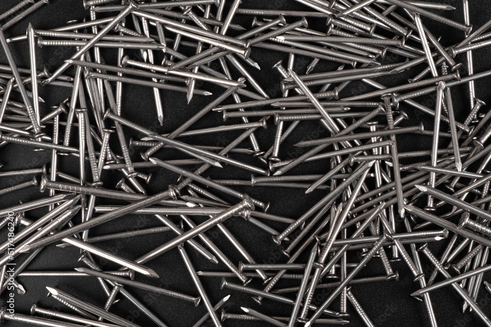 scattered metal nails on a black background.