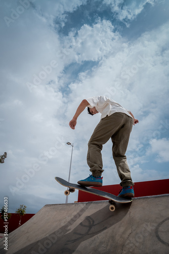 Young skateboarder male in a skate park
