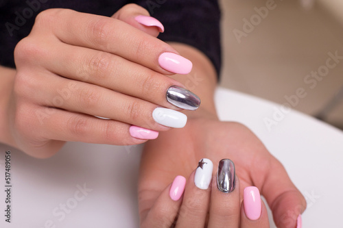  Beautiful female hands with colourful manicure nails, pink and silver colored gel polish