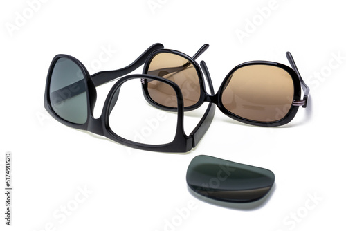 Broken and whole sunglasses, made of glass and plastic, lens falling out of frame, isolated on white background