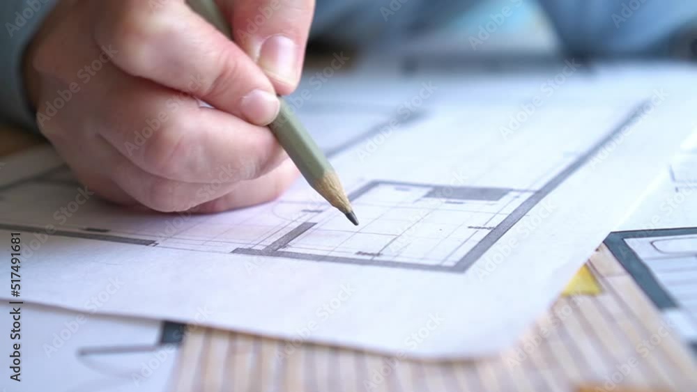 Designer is working on a new apartment project. Woman studies the plan of the apartment and thinks over the repair. Close-up Designer is working on a new apartment project. Woman studies the plan of the apartment and thinks over the repair. Close-up