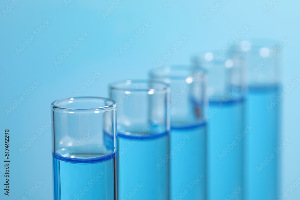 Test tubes with reagents on light blue background, closeup. Laboratory analysis Test tubes with reagents on light blue background, closeup. Laboratory analysis