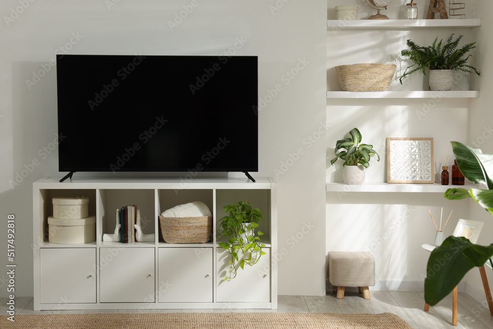 Stylish wide TV set on stand in room Stylish wide TV set on stand in room