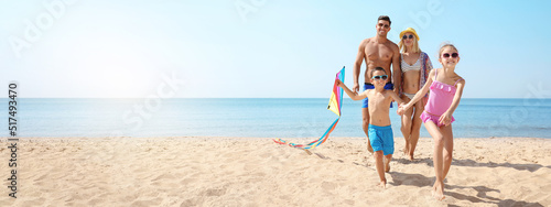 Happy family with kite at beach on sunny day, space for text. Banner design