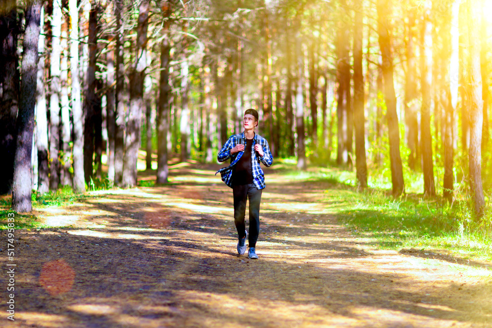 Teenage boy taking a walk in a sunlit summer park. Teenage boy taking a walk in a sunlit summer park.