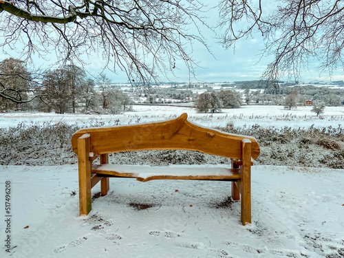 A seat looking over the English countryside covered in winter snow