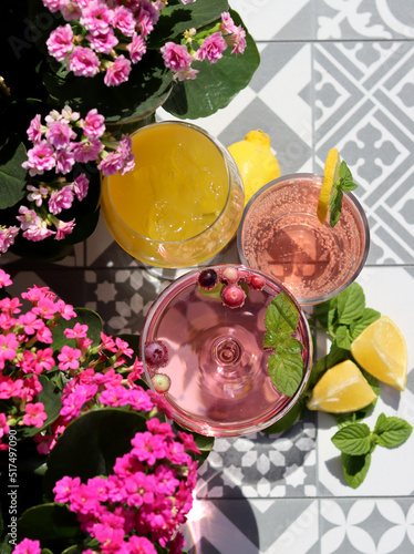 Refreshing summer cocktails on a garden table. Close up photo of glasses with various drinks. Party in a garden. 