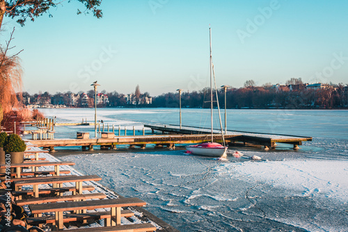 Sailing boat, yacht waiting for the summer at frozen port, Hamburg, Aussenalster in Winter