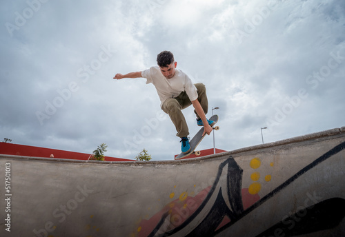 young skateboarder jumps over a bowl in a skate park © magui RF