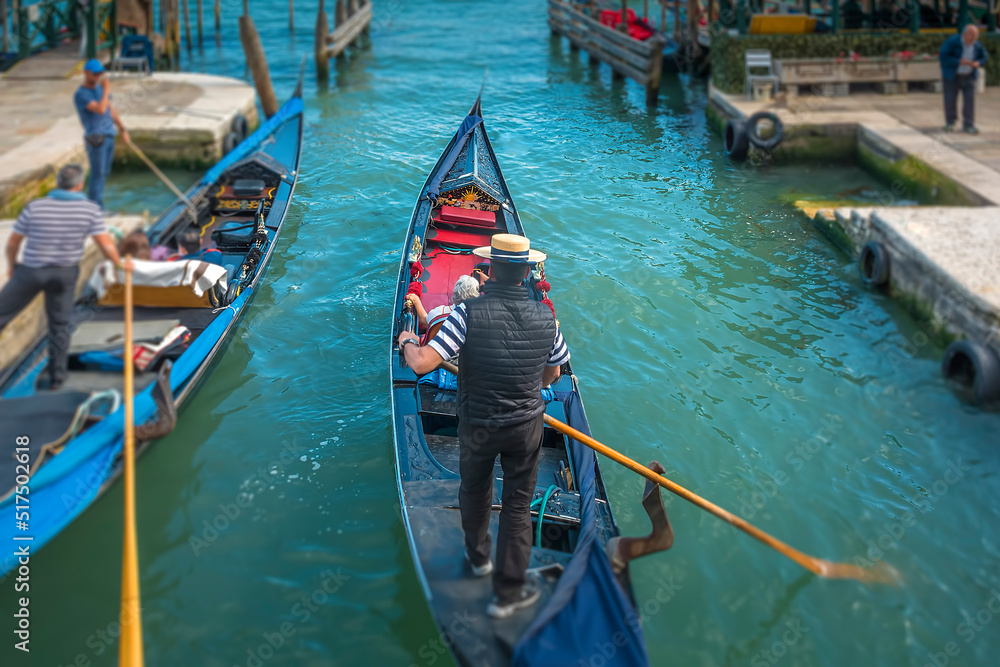 Gondoliere riding his Gondola on a canal in Venice, Italy 