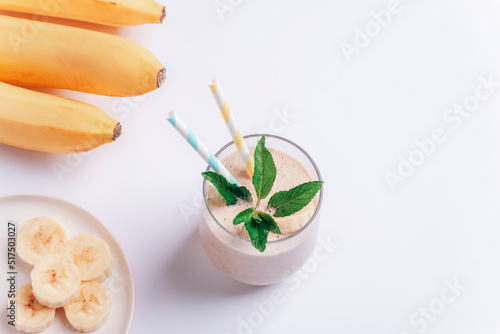 Banana smoothie with ingredients on white background. Top view, flat lay