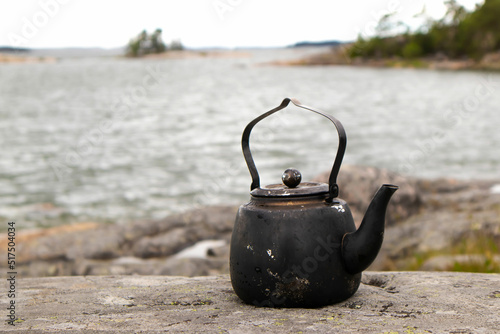Kettle in the nature. Sea horizon in the background. Hiking and outdoor recreation concept.