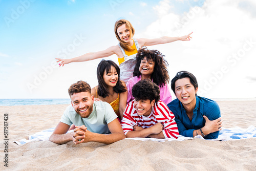 Group of young best friends bonding outdoors - Multiracial people bonding and having fun at the beach during summer vacation
