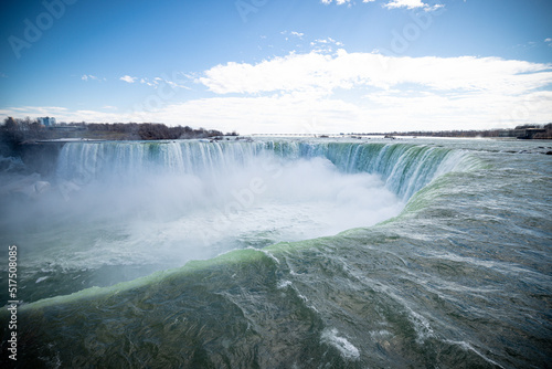 Horseshoe Falls at Niagara Falls Canada are pouring water through frozen landscape at winter