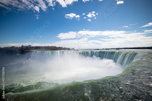 Horseshoe Falls at Niagara Falls Canada are pouring water through frozen landscape at winter