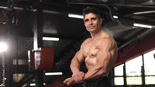 Portrait Mature Shirtless Bodybuilder Man Showing Biceps Muscles To Camera
