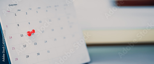 Embroidered red pins on a calendar event Planner calendar,clock to set timetable organize schedule,planning for business meeting or travel planning concept. photo