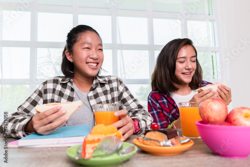 Teenage girls enjoy eating breakfast before go to school, Back to school concept