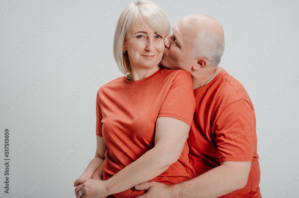 couple in love in orange t-shirts on a white background couple in love in orange t-shirts on a white background