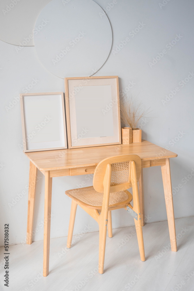 Fototapeta premium Portrait white picture frame mockup on wooden table. Modern ceramic vase with eucalyptus. White wall background. Scandinavian interior. 