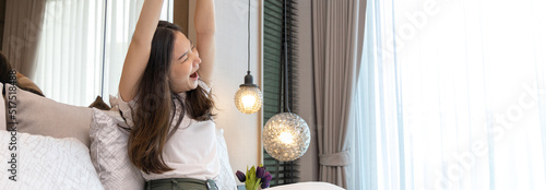 Tableau sur toile Stretch oneself, Beautiful Asian woman waking up in the morning in her modern bedroom in her new home, Wake up to a bright and comfortable morning in a luxurious room, Refreshing body, Sleep well