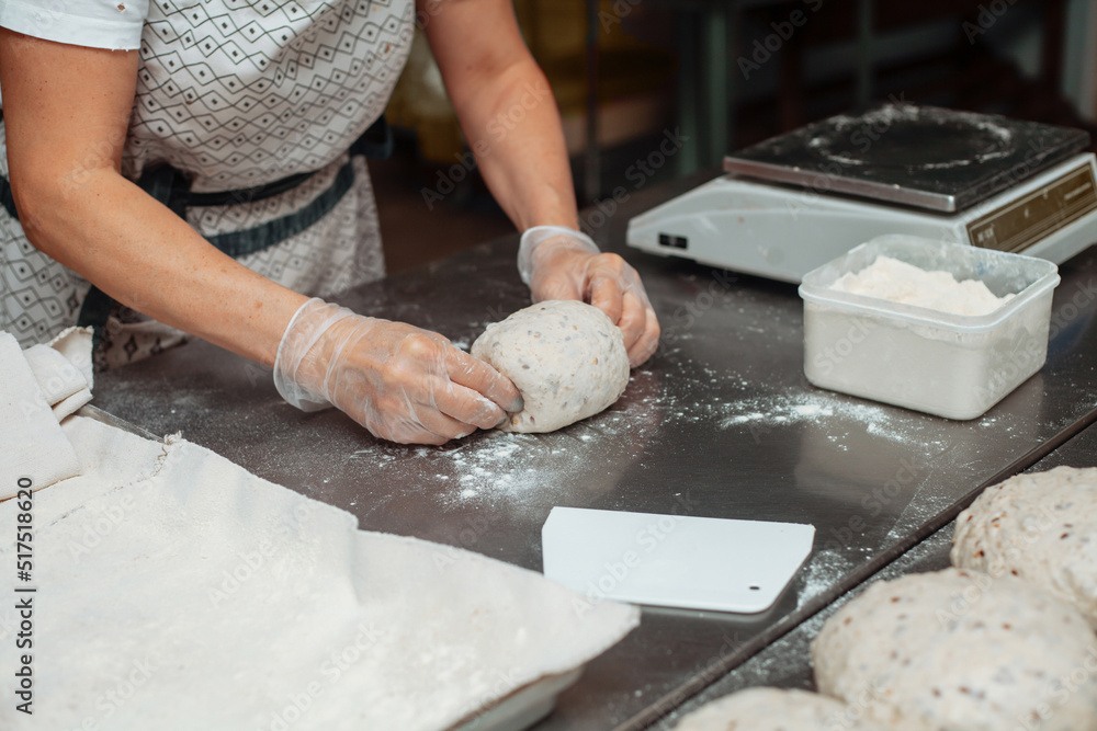 baker shaping bread raw dough before baking on the table in bakery baker shaping bread raw dough before baking on the table in bakery