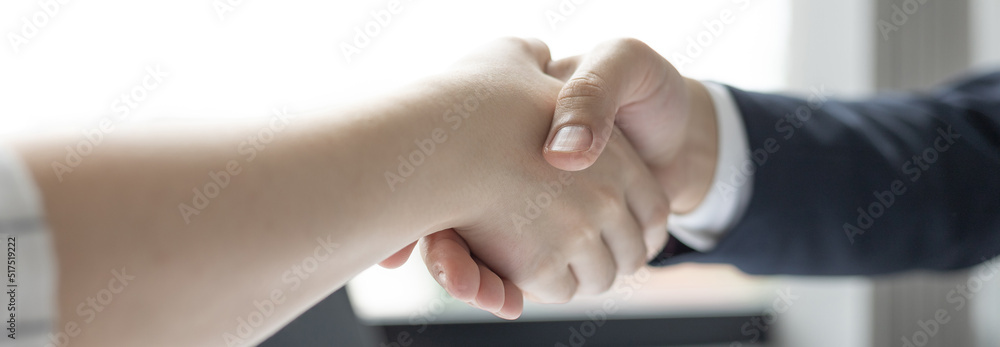 Obraz premium Business personage handshake, Asian business women congratulate on being a corporate partnership with European male investors, Friendship, Sign language greetings, Successful business negotiations.
