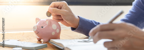 Man puts a coin dollar in a piggy bank, Saving money for future growth and knowing how to manage your spending wisely, Saving money for business growth or long-term profitability.