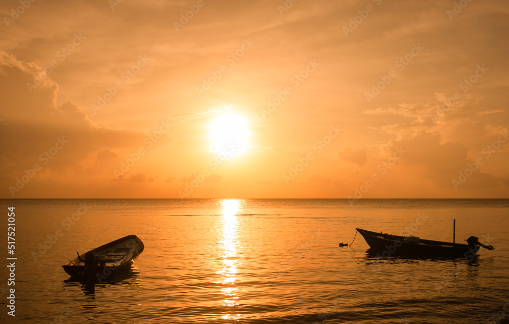 Fisherman boats in sea during sunset on Maldives islands. Beautiful sun. Orange light. Backlight travel photo.