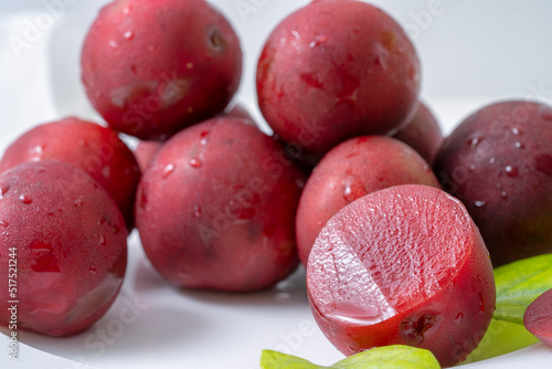 red plums on a white table