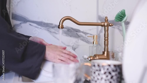 Woman wash up plate with soap and water in kitchen sink closeup at home