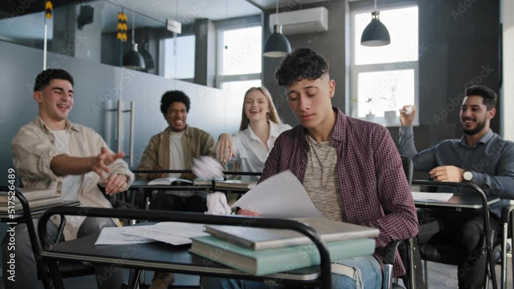 Students sitting in classroom laughing at classmate young frustrated worried guy suffering from ridicule bullying abuse feels like loser upset distressed oppressed student feeling loneliness offended Students sitting in classroom laughing at classmate young frustrated worried guy suffering from ridicule bullying abuse feels like loser upset distressed oppressed student feeling loneliness offended
