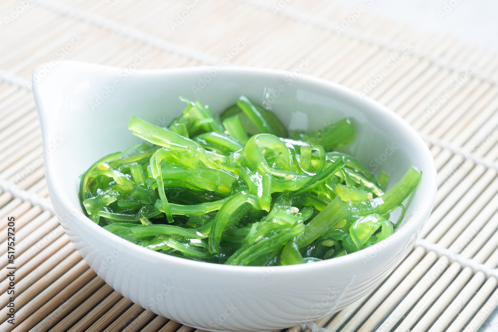 Japanese Wakame Seaweed Salad with Chopsticks, close up. Healthy vegetarian seafood Japanese Wakame Seaweed Salad with Chopsticks, close up. Healthy vegetarian seafood
