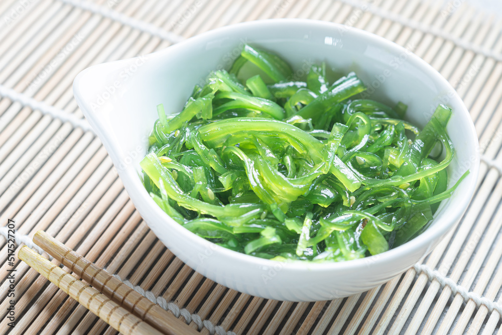 Japanese Wakame Seaweed Salad with Chopsticks, close up. Healthy vegetarian seafood Japanese Wakame Seaweed Salad with Chopsticks, close up. Healthy vegetarian seafood