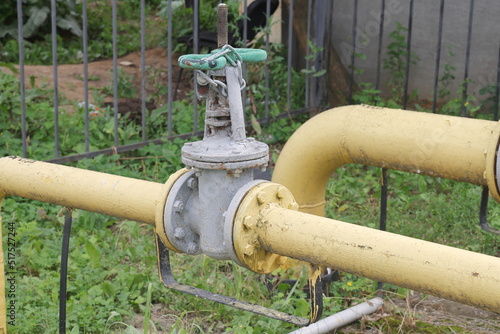 Shut-off valve on gas pipe. Fragment of pipeline with valve. Valve on pipe in boiler room. Concept - shutting off gas supply. Flap to shut off gas flow. Yellow steel pipeline close up photo