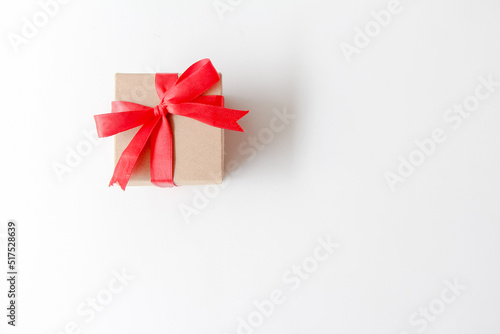 Brown paper gift box with red ribbon on white background. copy space, top view