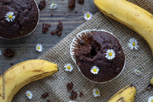 brauner Muffin mit Schokostückchen, Bananen und Blumen