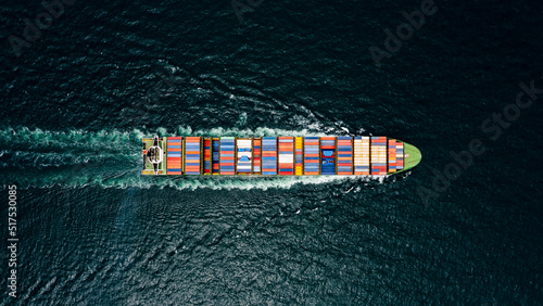 container cargo ship sailing full speed in pacific ocean to transport goods import export internationally or worldwide as business and industrial transport and marine services open sea aerial top view