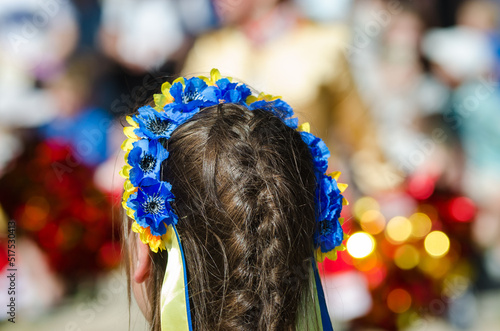 A girl in a wreath of yellow and blue flowers, the colors of the Ukrainian flag