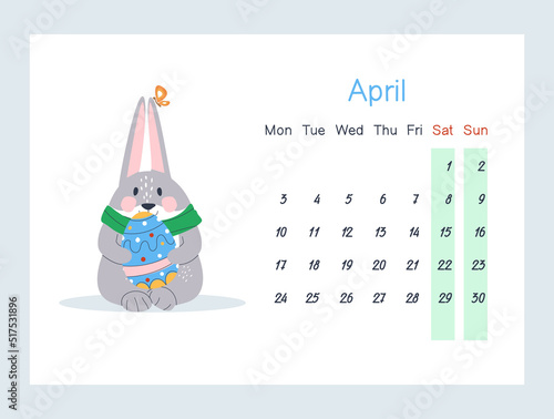 A hare sits with a painted Easter egg in its paws. Easter Bunny. April 2023 calendar. Week starts on Monday, Saturday and Sunday are greyed out. Flat vector illustration photo