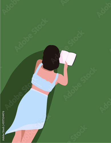 A girl on the grass. The girl is reading. A girl reads a book on a picnic in the summer