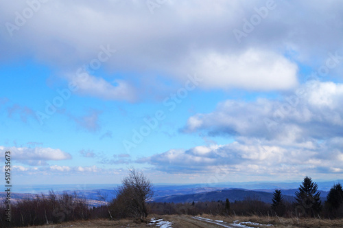 View of the autumn Carpathian mountains under the sky with white and gray clouds on a cloudy autumn day