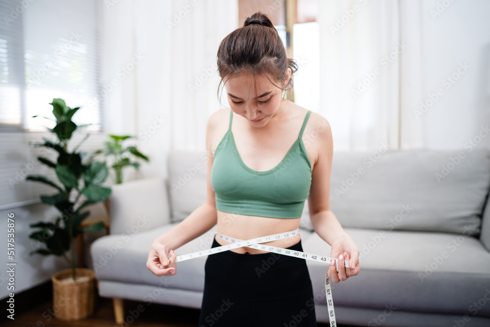 Close up thin woman measuring her hip with tape measure. Close up thin woman measuring her hip with tape measure.