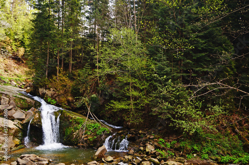 View of Kamianka waterfall with stormy water falling from large stones on a spring day