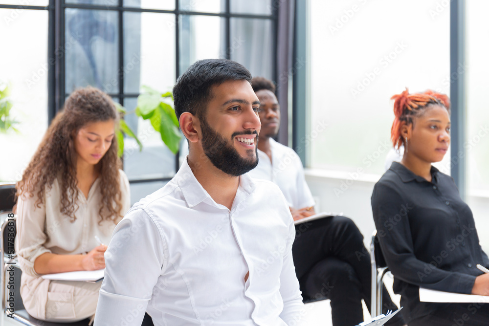 Group of diverse young people sitting in a conference room. Group of diverse young people sitting in a conference room.