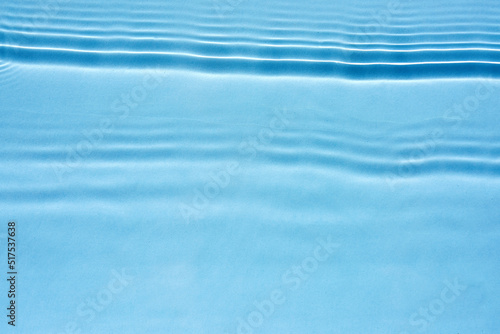Transparent blue water surface texture with horizontal waves and ripples
