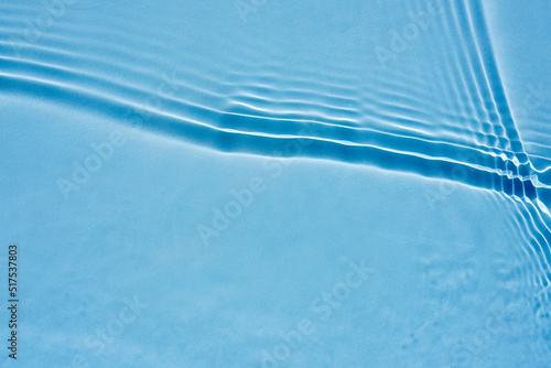 Beautiful oncoming waves, ripples on clear water, blue background