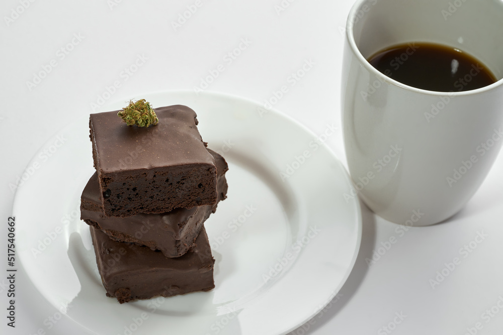 Coffee and marijuana bud on cake pieces on plate Coffee and marijuana bud on cake pieces on plate