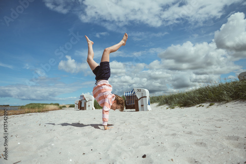 Happy teen girl joyful jumping on white beach at Baltic sea at summer holidays